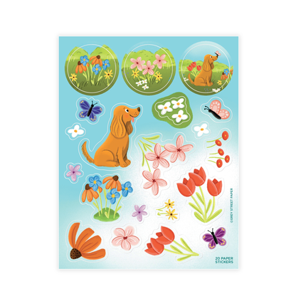 A paper sticker sheet with various designs including a cute dog, butterflies, and colorful flowers on a blue background. The sheet is labeled as 20 paper stickers and has a 'Made in USA' label.