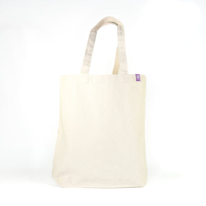 Back view of natural cream cotton tote bag with Grey Street Paper purple label tag on white background
