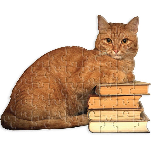 A jigsaw puzzle with mini pieces. Puzzle shaped like a cat lying on a stack of books.